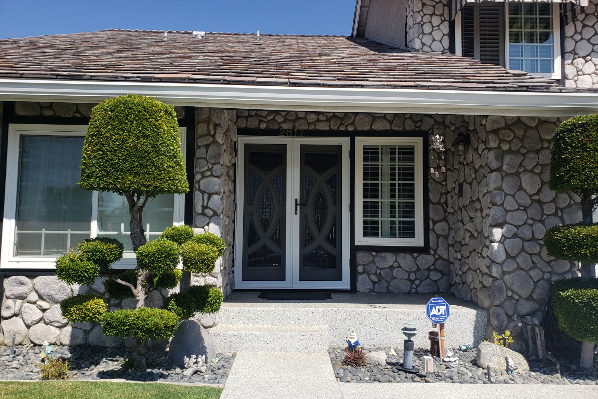 A home with a beautiful entryway with security screen doors installed blending decorative styling with high-level protection, enhancing curb appeal and boosting home value in Southern California.