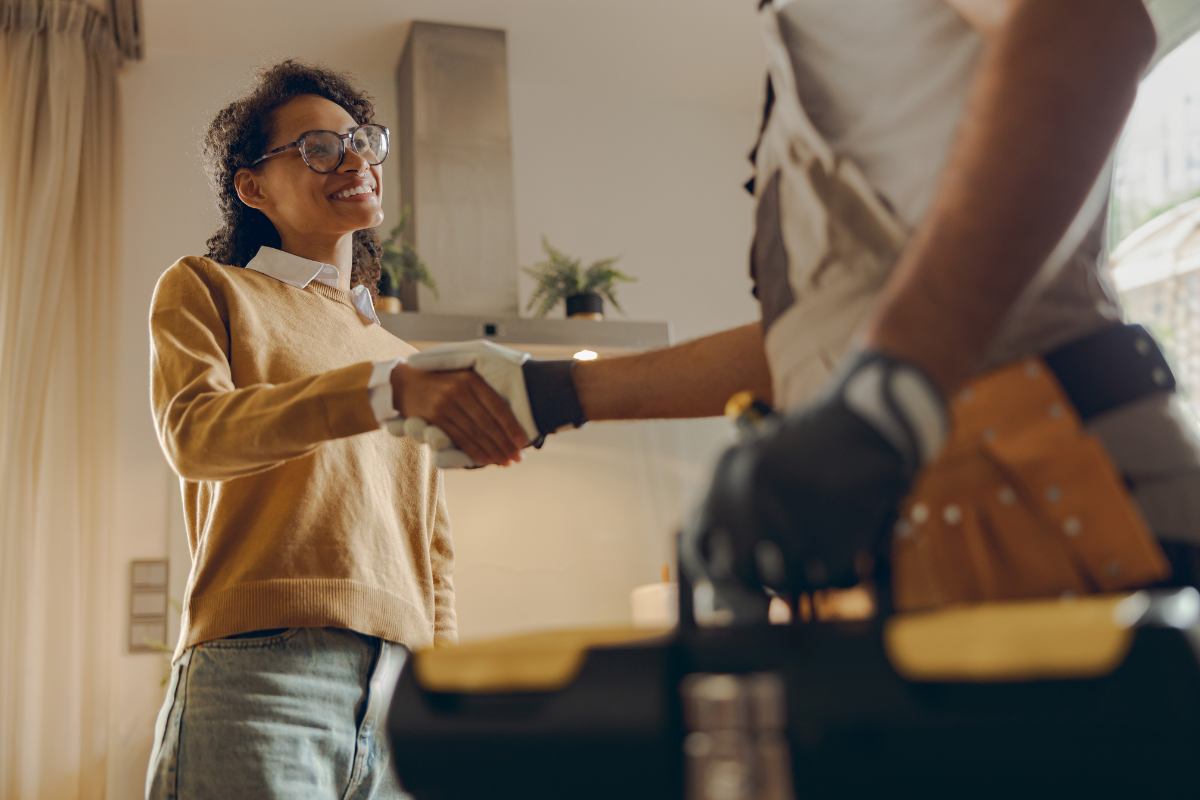 A homeowner shaking hands with a professional service technician after a successful security screen installation in Southern California.